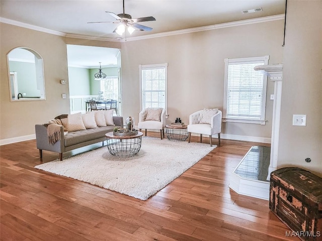 living room with hardwood / wood-style floors, ceiling fan with notable chandelier, and crown molding