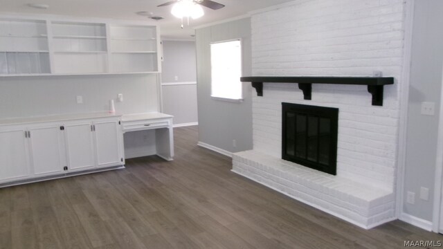 unfurnished living room featuring dark hardwood / wood-style floors, ceiling fan, crown molding, and a brick fireplace