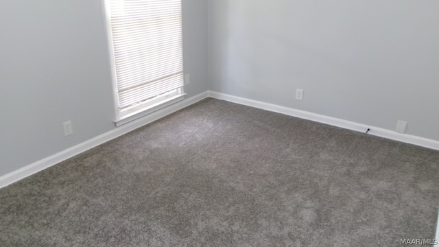 unfurnished room featuring dark carpet