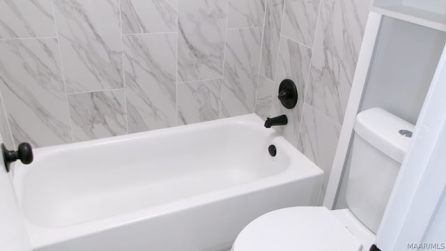 bathroom with tiled shower / bath and toilet