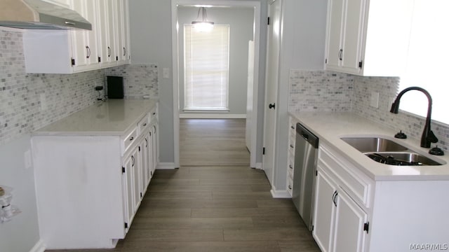 kitchen with backsplash, wall chimney range hood, sink, and white cabinets