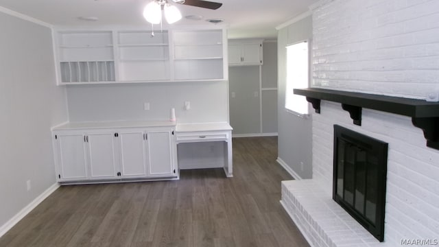 unfurnished living room with a brick fireplace, ceiling fan, dark hardwood / wood-style floors, and crown molding