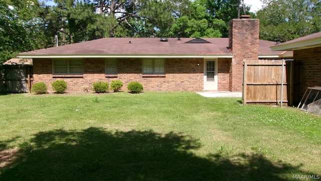 back of property featuring a lawn