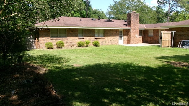 rear view of house featuring a lawn