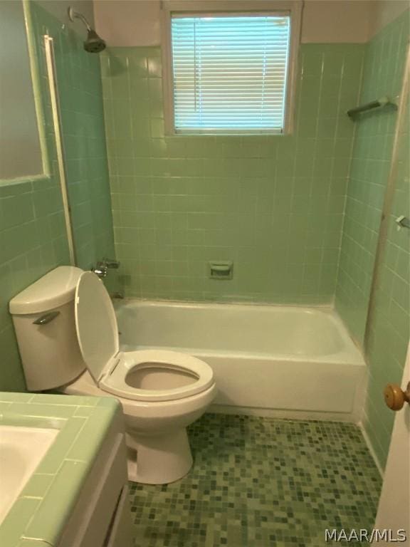 full bathroom with toilet, vanity, and tiled shower / bath combo