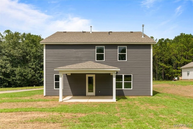 rear view of house with a yard and a patio area