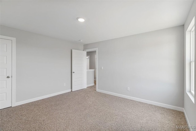 unfurnished bedroom featuring carpet and multiple windows