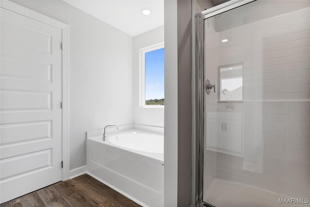 bathroom with hardwood / wood-style floors and shower with separate bathtub