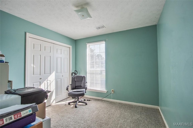 office featuring a textured ceiling, carpet flooring, baseboards, and visible vents