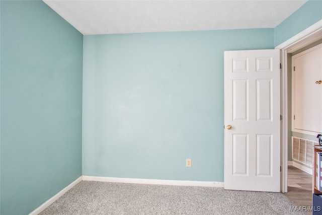 spare room featuring a textured ceiling and carpet