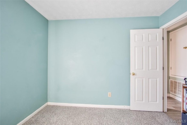 empty room featuring baseboards and carpet floors