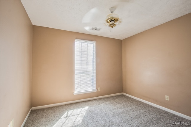 empty room featuring carpet and a textured ceiling