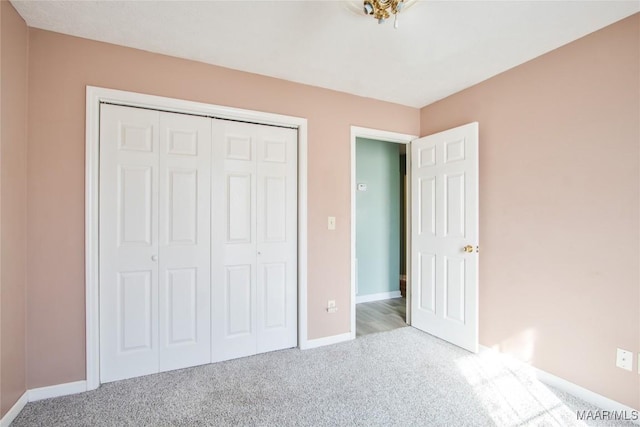 unfurnished bedroom featuring carpet, a closet, and baseboards