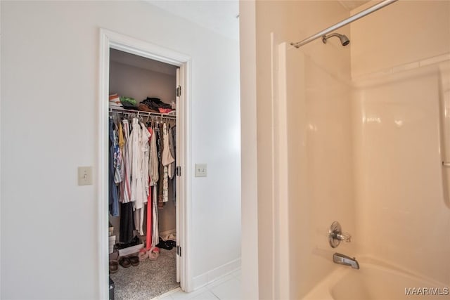 bathroom with a spacious closet and bathtub / shower combination