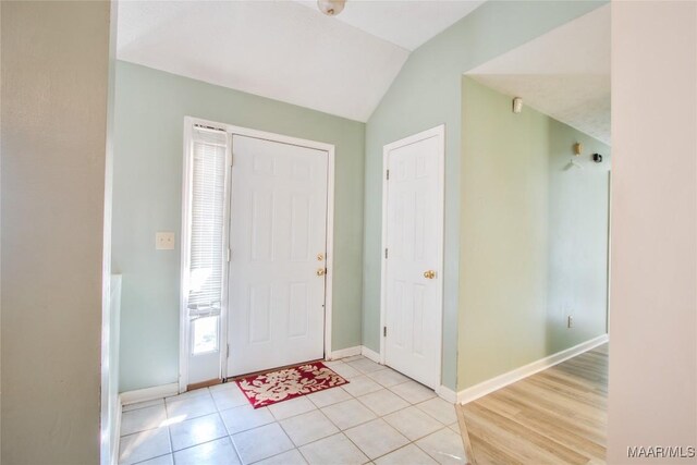 entrance foyer featuring baseboards and lofted ceiling