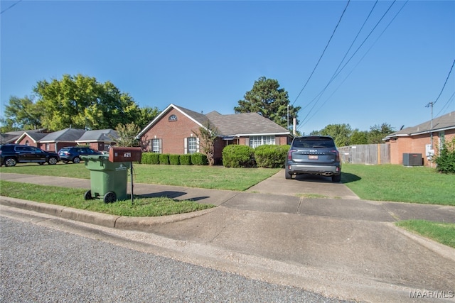 bungalow with cooling unit and a front lawn