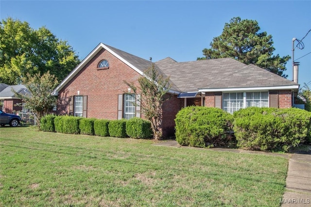 ranch-style home with a front yard and brick siding
