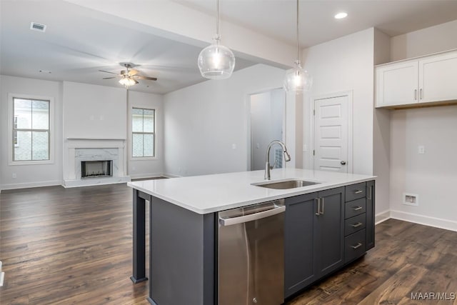 kitchen with white cabinetry, sink, hanging light fixtures, a kitchen island with sink, and stainless steel dishwasher