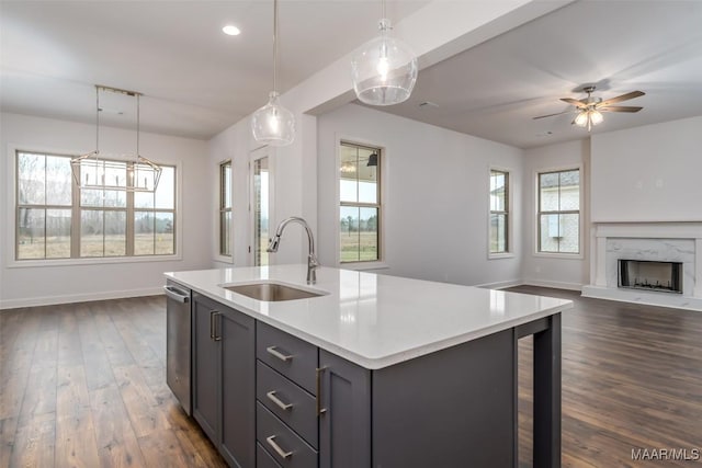 kitchen featuring pendant lighting, plenty of natural light, sink, and a center island with sink