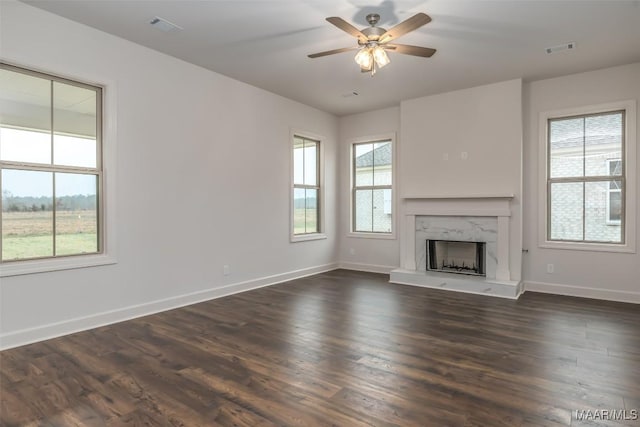 unfurnished living room featuring ceiling fan, a premium fireplace, and dark hardwood / wood-style flooring