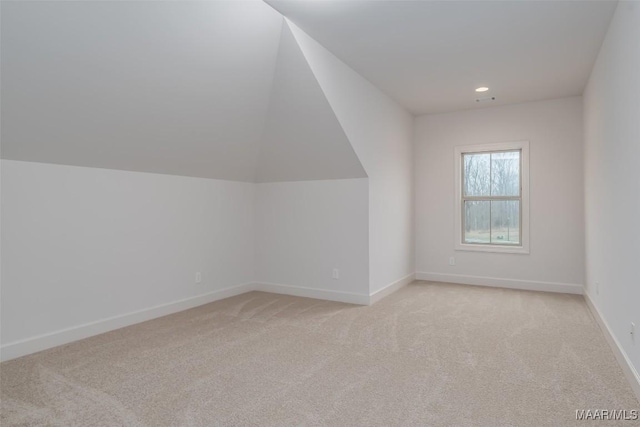 additional living space with vaulted ceiling and light colored carpet