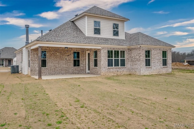 rear view of house with central AC unit, a patio, and a lawn