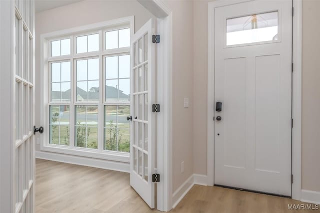 foyer with baseboards and light wood-style flooring