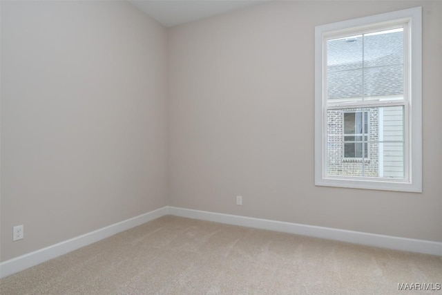 unfurnished room featuring light colored carpet and baseboards