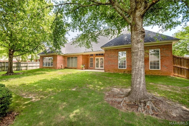 rear view of property featuring a lawn and french doors