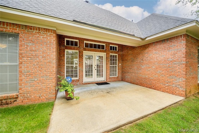 view of exterior entry with a patio area and french doors