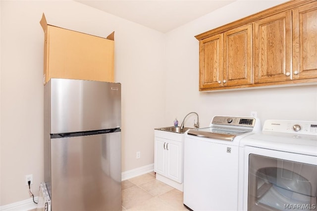 clothes washing area with separate washer and dryer, sink, and light tile patterned floors