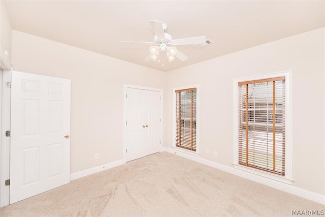 empty room with ceiling fan and light colored carpet