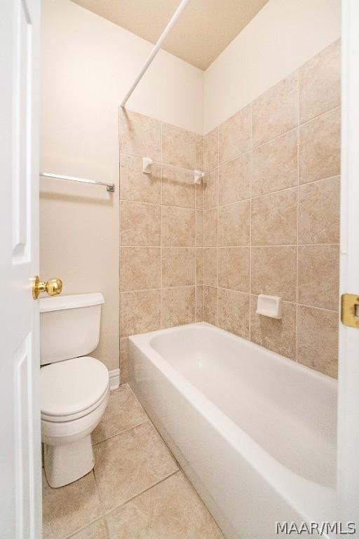 bathroom with tile patterned floors, tiled shower / bath combo, and toilet