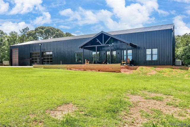 exterior space with an outbuilding, central AC unit, and a lawn