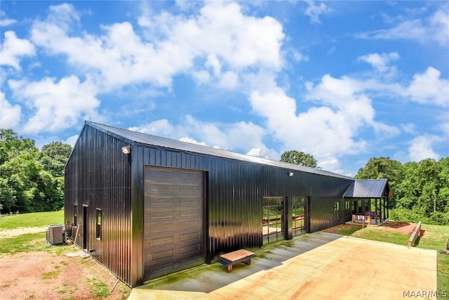 view of outbuilding with central air condition unit and a garage