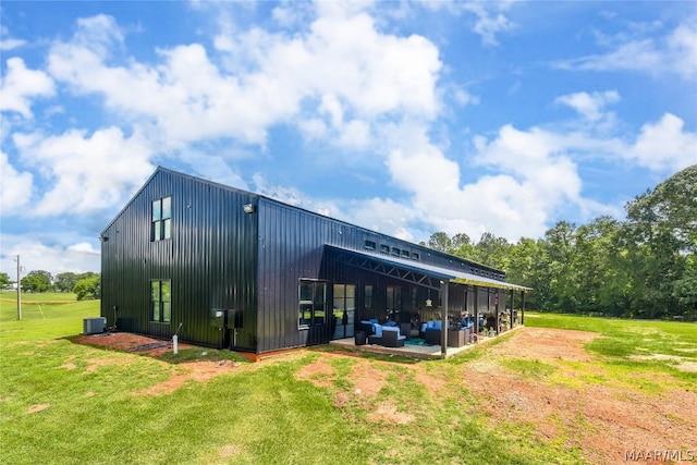 view of outbuilding featuring a lawn, central air condition unit, and outdoor lounge area