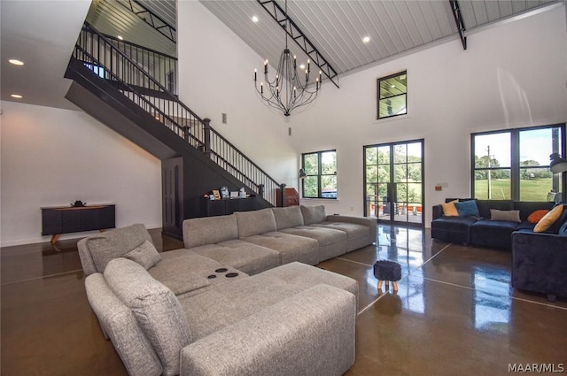 living room with french doors, a towering ceiling, an inviting chandelier, and plenty of natural light