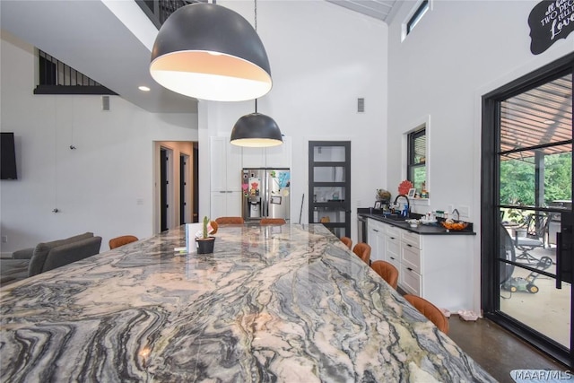 dining area featuring a towering ceiling, sink, and french doors