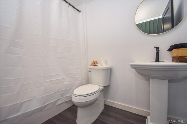 bathroom with a shower with shower curtain, hardwood / wood-style flooring, and toilet