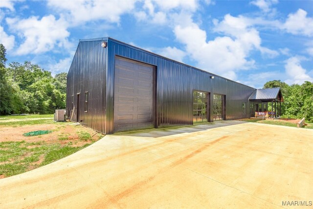 view of outbuilding featuring central AC and a garage