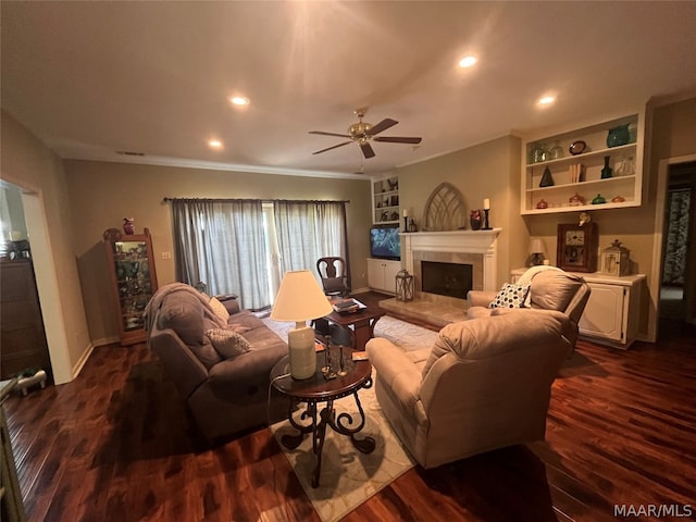 living area featuring ceiling fan, recessed lighting, dark wood-type flooring, a fireplace, and ornamental molding