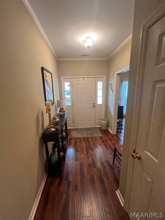 entryway with baseboards, visible vents, dark wood-type flooring, and ornamental molding