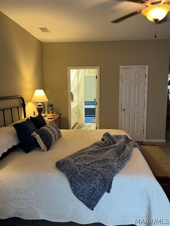 bedroom featuring a ceiling fan, visible vents, and ensuite bath