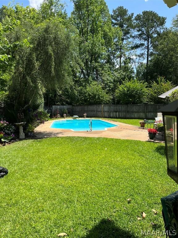 view of swimming pool with a fenced in pool, a fenced backyard, a lawn, and a patio