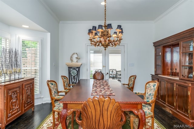 dining room with a notable chandelier, dark wood-type flooring, french doors, and crown molding