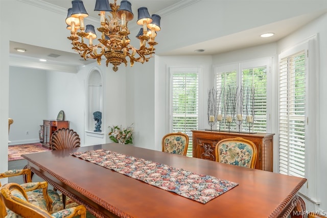 dining space featuring a healthy amount of sunlight, crown molding, and a chandelier