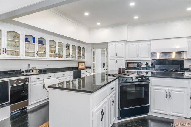 kitchen with white cabinetry, premium range hood, and black appliances