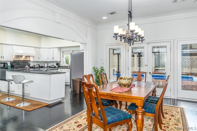 dining area featuring a chandelier, french doors, dark hardwood / wood-style floors, and crown molding