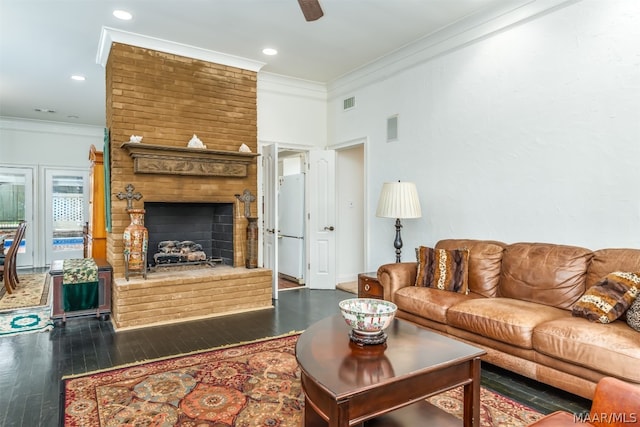 living room featuring dark hardwood / wood-style flooring, ceiling fan, a fireplace, and crown molding