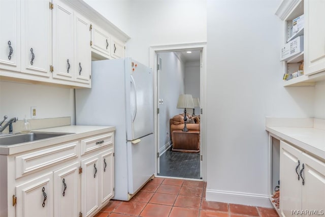 kitchen with a sink, open shelves, light countertops, and white cabinets